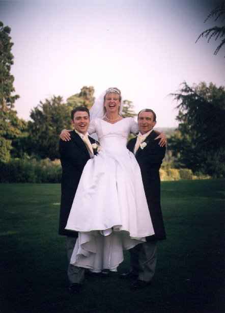 Happy bride lifted in two pairs of loving arms.